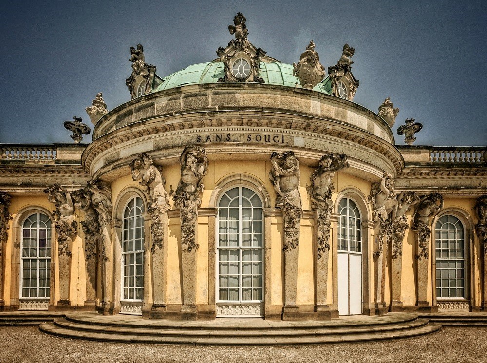 Historic Sanssouci Palace with ornate sculptures and arched windows in Potsdam, Germany.